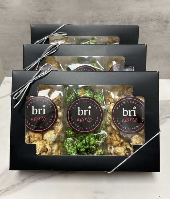 Bri Marie gourmet popcorn gift boxes stacked neatly with ribbon ties and assorted flavored popcorn varieties.